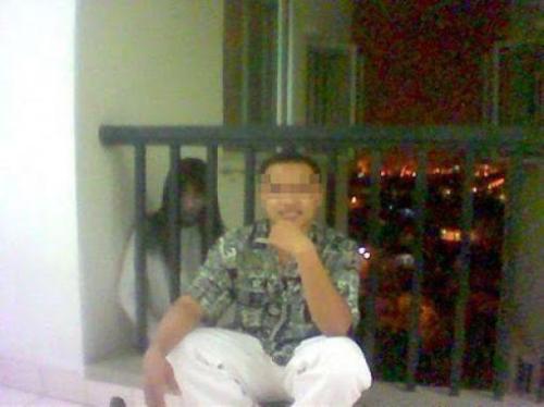 男性の後ろに誰かいるの写真